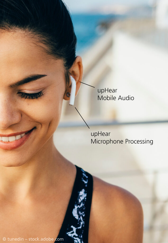 A woman wearing earbuds. There is text attached to the earbud mentioning "upHear Mobile Audio" and "upHear Microphone Processing".